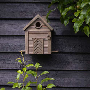 bruin design vogel huisje in aan zwarte schutting