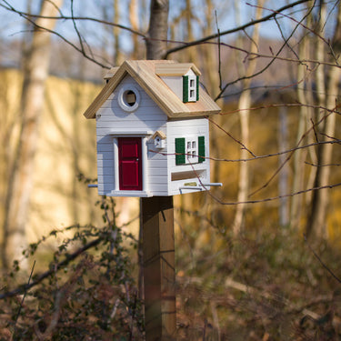 witte multiholk op houten paal buiten